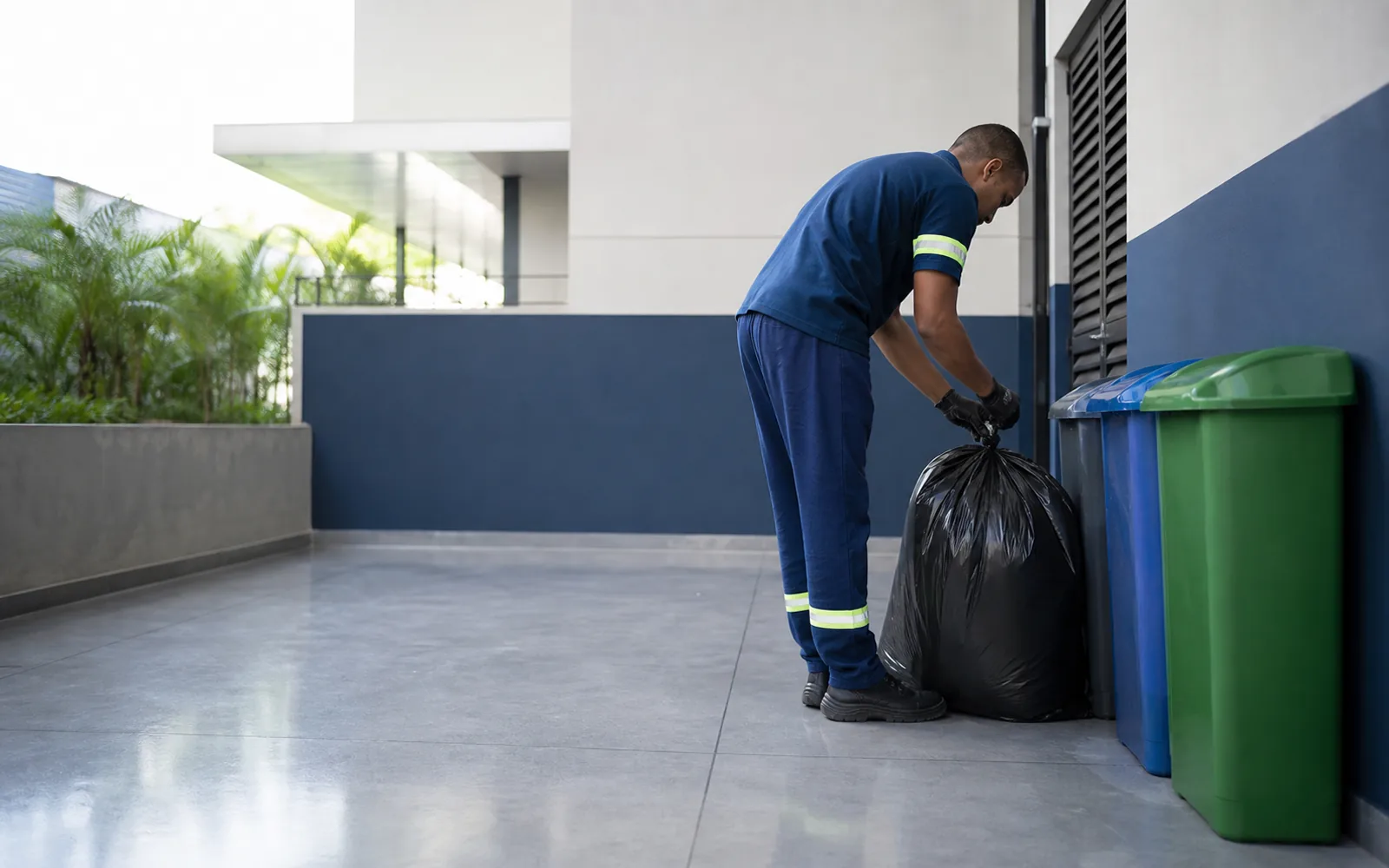 Profissional organizando a coleta de resíduos em área de serviço empresarial limpa